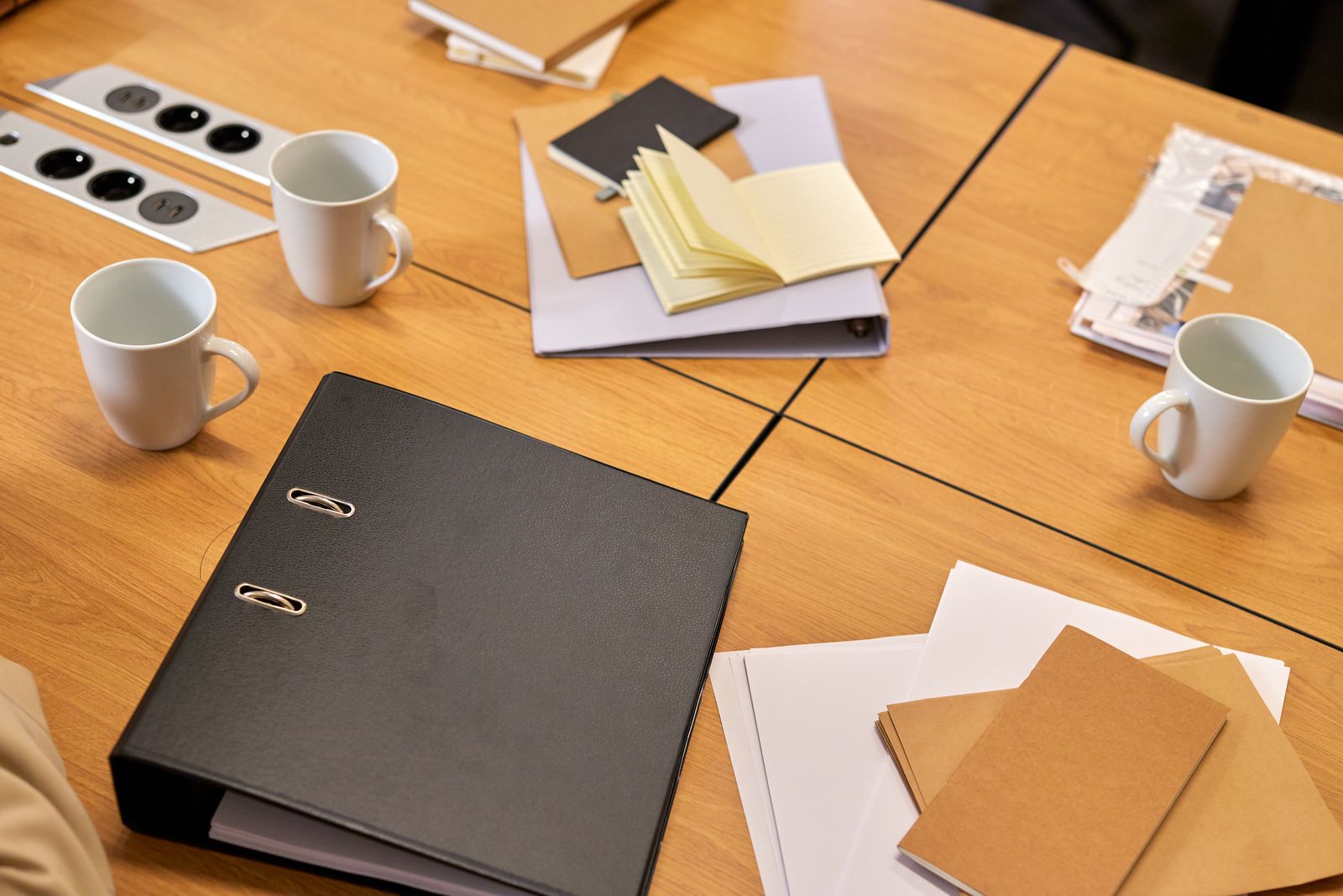Binders and papers stacked on an office desk